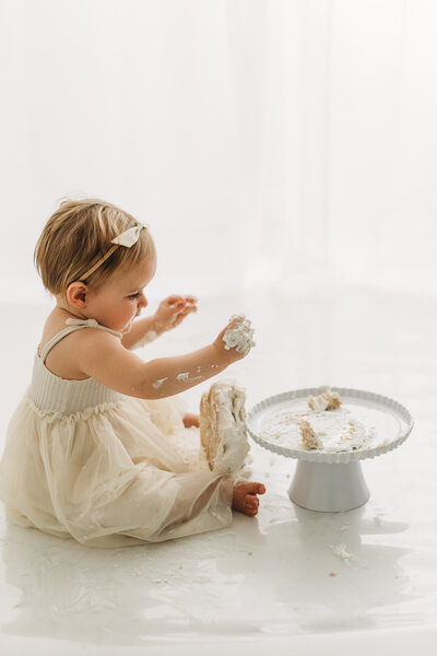 Cake smash session in Kelowna B.C with baby covered in white neutral cake