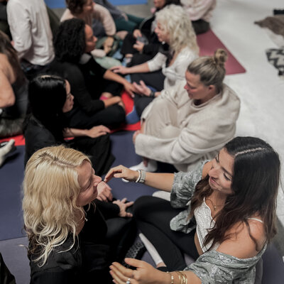 A group of women doing an intimate non-duality exercise during a kundalini activation process weekend immersion in Santa Monica California 