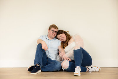 man and woman standing by lake laughing and hugging