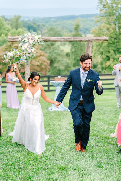 bride and groom excitedly walking down aisle after first kiss