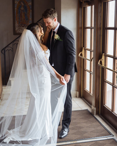 A catholic couple poses for a portrait in dramatic lighting while staring into each others eyes after their catholic wedding at st. ann's catholic church in Nashville