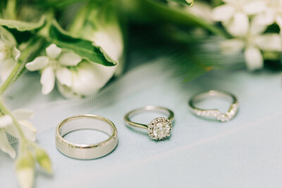 close up of bride and groom's engagement and wedding rings on top of invitation winx photo knoxville wedding photographer
