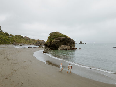 bride and groom running on beach