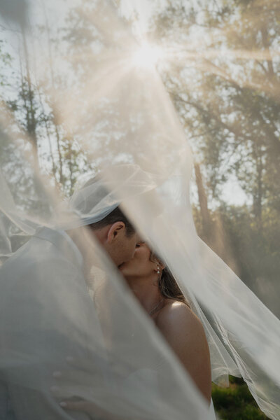 Bride and groom under her veil during wedding portraits in Comox by Latitude 49 Photography