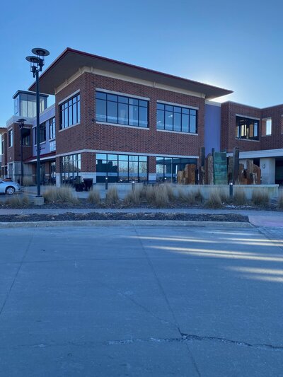 Exterior view of the Urbandale therapy office, a brick building with a welcoming entrance and parking lot.