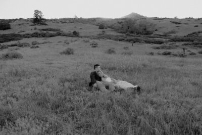Sweet couple relaxing in a field in the mountains.