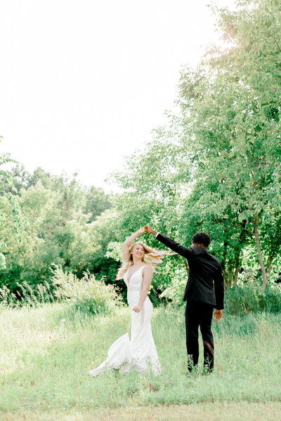 groom spinning bride in a field by wedding photographers in miami fl
