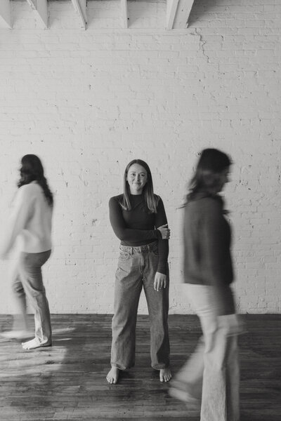 portrait photo in studio of two girls walking by while focusing on someone 