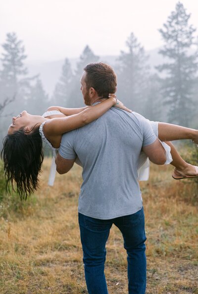 Romantic, rainy mountain engagement photos carrying his fiancee through the fog