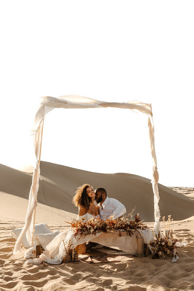 Couple shares an intimate dinner at their sand dunes utah elopement.