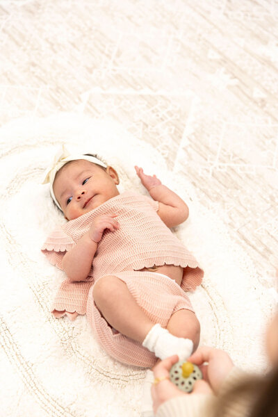 Baby laying on a blanket on the floor