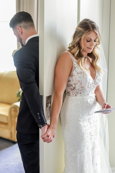 bride and groom holding hands behind door