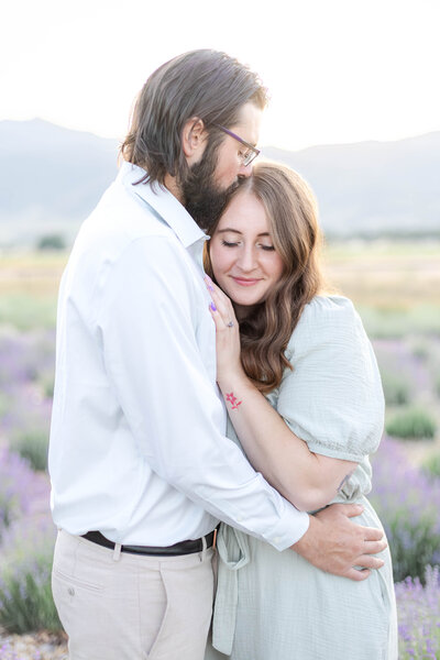 Romantic Utah engagement photo session at sunset, featuring lavender and a mountain backdrop and candid couple poses. Perfect inspiration for natural, light-filled engagement photography.
