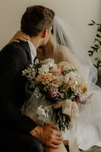 Closeup photo of a bride and groom sharing a sweetly intimate hug.