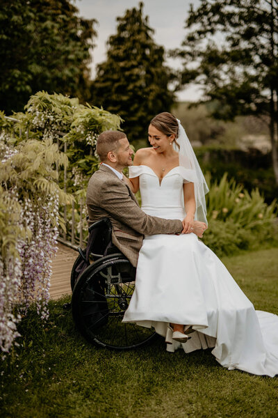 Joyful bride and groom walking through the gardens at Caswell House