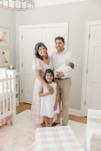 Family posing in nursery with new baby. - Newborn Photography Greenville SC