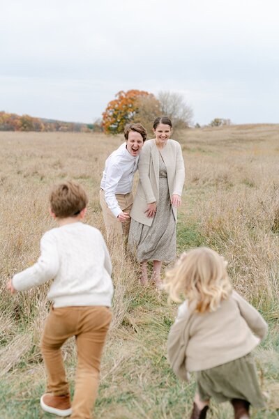 Two children running to their parents in a Wisconsin field, captured by Abby Park Photography
