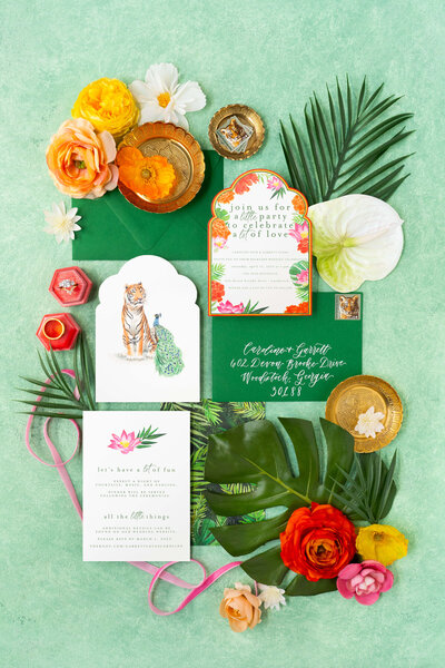 Bright and eye-catching Indian wedding invitation suite with tropical flowers and a peacock and tiger illustration by E Stokes Creations