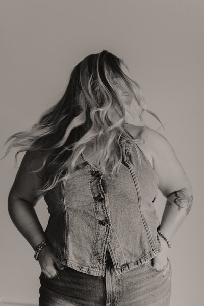 A photo of a young girl wearing a denim top shaking her head back and forth with her blond hair flying across her face. Branding photography in Northeast TN. 