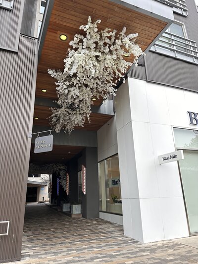 Custom floral installation with white blooms for Austin storefront design, created for a high-impact retail experience.