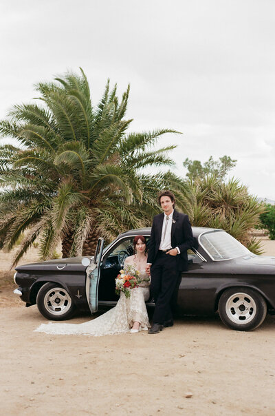 Film photograph of a couple and vintage car at Joshua Tree wedding captured by Caiifornia candid film wedding photographer.