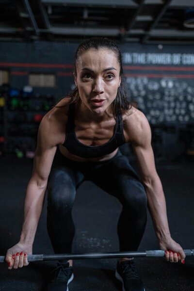 Female trainer deadlifting