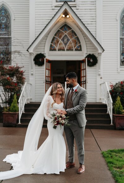 bride and groom standing outside of a church