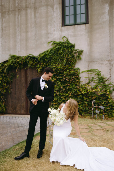 Candid and romantic wedding portrait of a joyful bride and groom against ivy-covered architecture, captured by editorial wedding photographer Madison