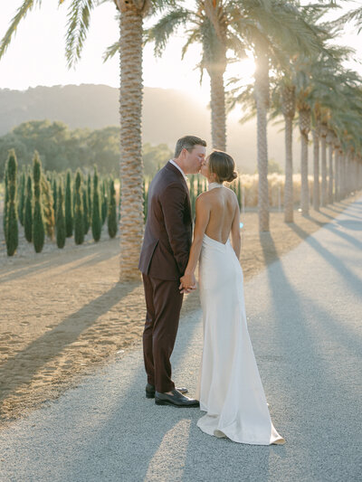 Bride and groom sharing a romantic kiss in the lush vineyards at Cayman Winery, a stunning Bay Area wedding venue.