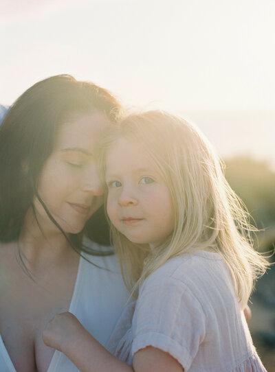 Mother cuddling her baby. Captured on film in beautiful light.