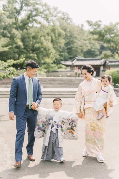 男の子の5歳の七五三写真。和装のママと妹、正装をしているパパと手をつないで、袴姿で満面の笑みの男の子が可愛らしい家族写真。横浜市で撮影。