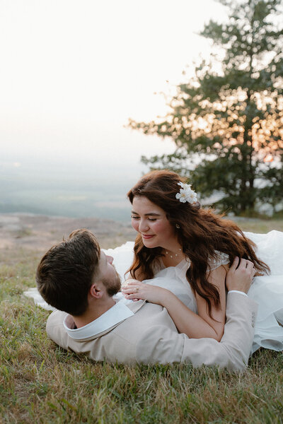 Aesthetic wedding photo of bride laying on groom's chest during their outdoor mountain elopement at Petit Jean Mountain State Park in Arkansas