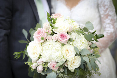 Closeup of bride and groom holding bouquet