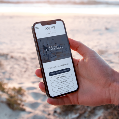 Forme Barre website shown on an iphone held by someone on a beach