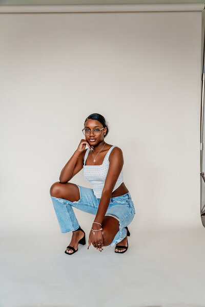 a beautiful senior girl squatting in a studio in downtown tacoma