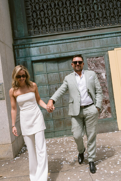 woman sitting on the floor leaning against a green couch with one arm rested up on the couch and the other draped across her body
