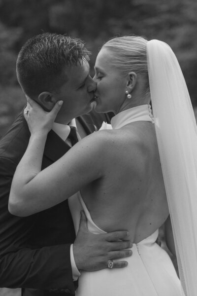 Bride and groom solo moment while kissing each other