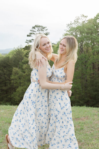 two sisters wearing white and blue dresses hugging each other