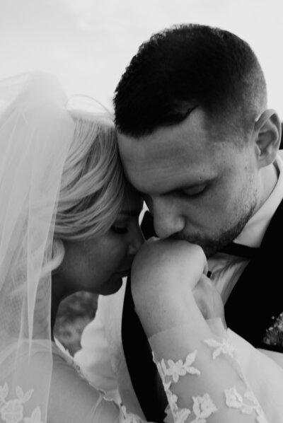Groom kissing bride's hand