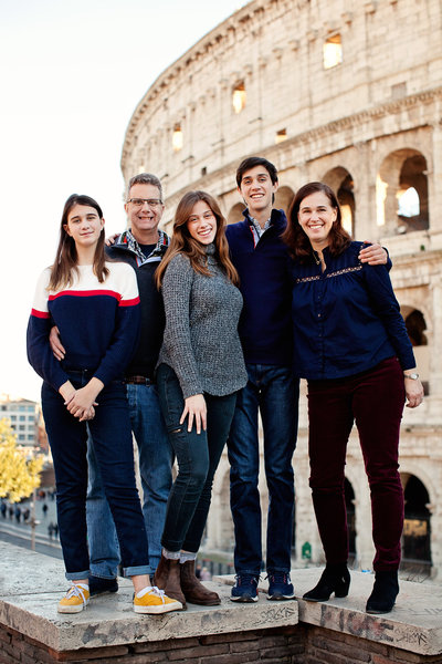 A family of five standing on the ledge above the Colosseum. Taken by Rome Family Photographer, Tricia Anne Photography