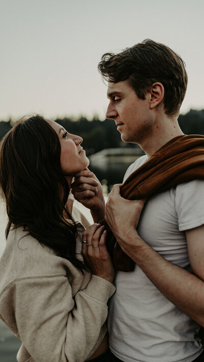 Couple closing eyes while bride holding the neck of the groom