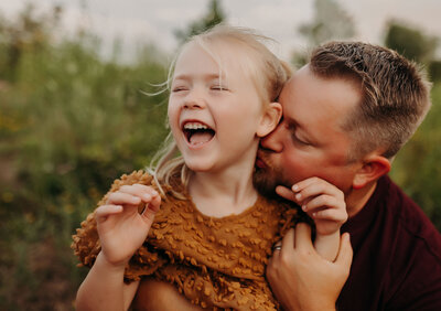 Young girl in her mother's arms with a serious face.