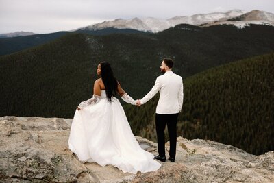 Bride and groom look out to mountains during mountain sunrise elopement.