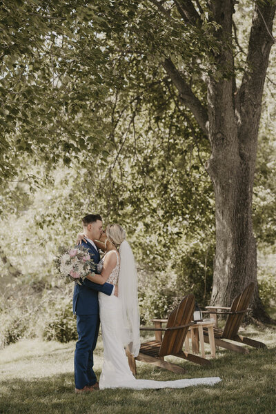 Bride and groom embracing outdoors under a tree