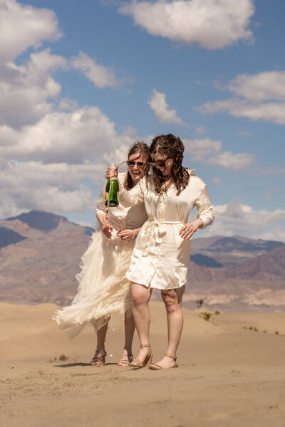 A bride in a beautiful wedding gown standing on the flowing, sweeping sand dunes of Mesquite Flat in Death Valley.