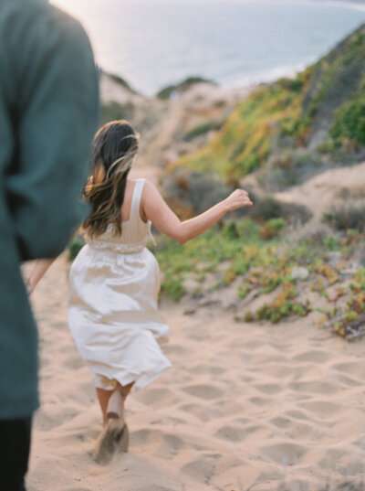 engaged girl running on beach