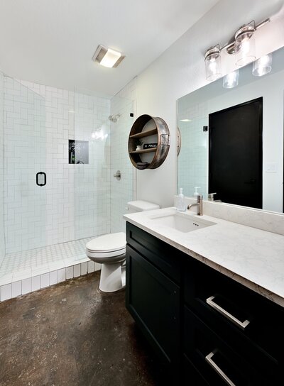 Bathroom with walk-in shower and large vanity in this two-bedroom, two-bathroom luxury condo in the historic Behrens building with skyline views, fully stocked kitchen, free WiFi and room for 6 in downtown Waco, TX.