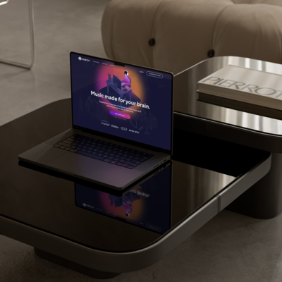 a macbook on a black table with a mockup of a service with music expertly designed for the brain called brand FM