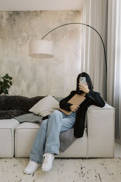 A Kmotion employee working on paperwork for a Showit website design project on a couch.

