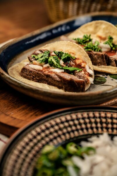 Tender steak tacos topped with fresh cilantro, onions, and a tangy salsa, wrapped in warm tortillas for a savory Tex-Mex treat.